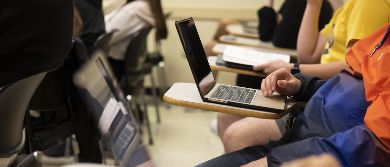 close up of students writing on computers